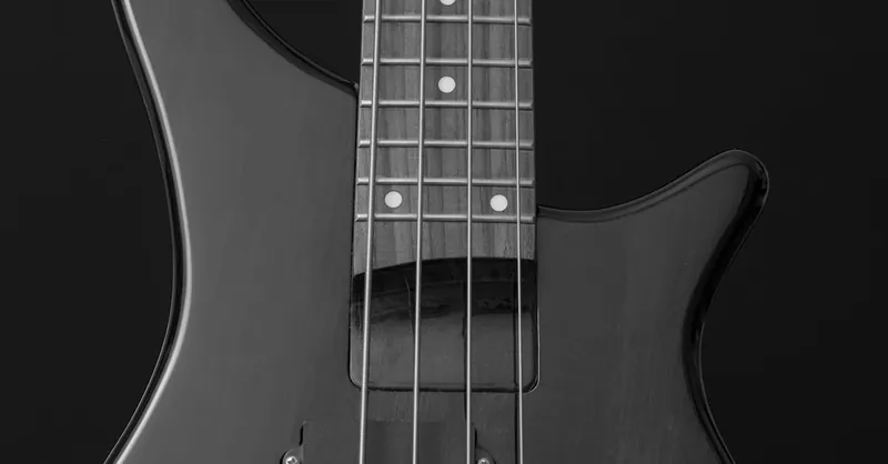 Detailed close-up of an electric guitar in black and white, showcasing strings and body.