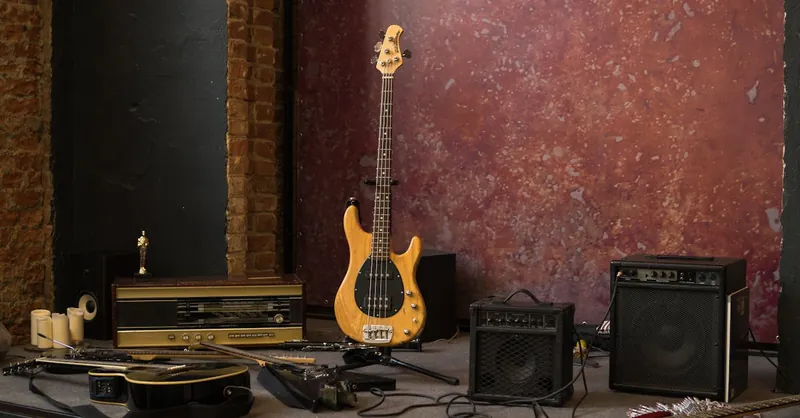 S type electric guitar placed on stage near various musical instruments and loudspeakers in shabby studio