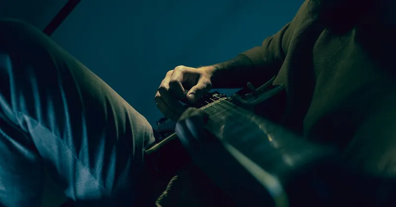 Moody close-up of a person skillfully playing an electric guitar.