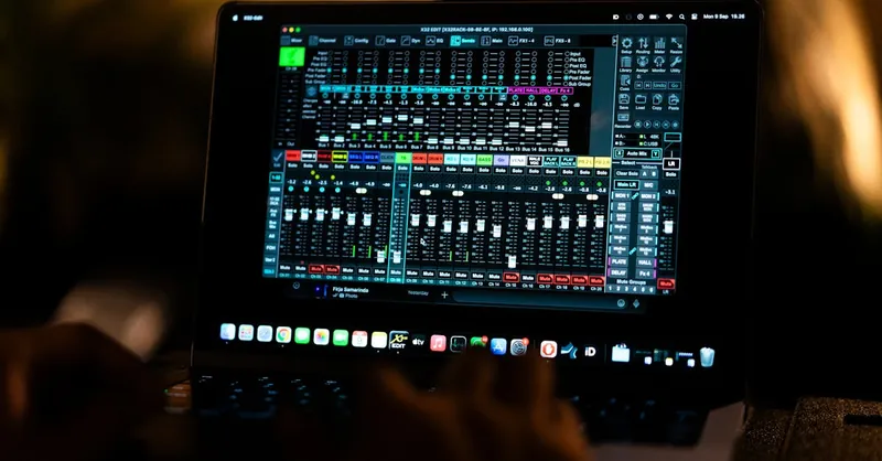 Close-up of a digital audio mixing software interface on a laptop screen in a recording studio.