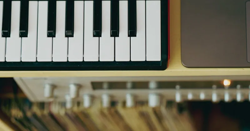 Top view of a MIDI keyboard and laptop arranged on a desk, capturing a modern music setup.
